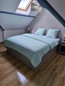 ein Schlafzimmer mit einem großen Bett im Dachgeschoss in der Unterkunft Charmant triplex familial au coeur du Pouliguen, proche de la plage et de la Baule in Le Pouliguen