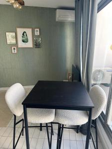 czarny stół i krzesła w pokoju z oknem w obiekcie Studio première ligne mer parking w mieście La Grande-Motte