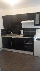 a kitchen with a sink and a microwave at Appartement coeur de ville! in Foix +5 photos