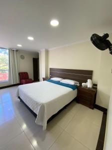 a bedroom with a large bed and a chair at Hotel santa fe plaza sucursal HBP in Santa Fe de Antioquia