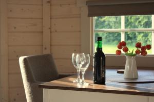 a bottle of wine sitting on a table with a wine glass at Finse Kota's Schotererf in Kuinre