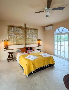 - une chambre avec un lit et un ventilateur de plafond dans l'établissement La Casa del Sol, à El Cuyo