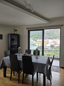 Un comedor con mesa y sillas y una gran ventana. en VIP Paradise Apartment, en Machico