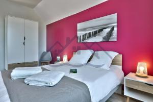 a bedroom with a large bed with a red wall at LocaLise - M2C - Ty Ma Bro -Maison avec extérieur entièrement clos - Wifi inclus - Draps inclus- Animaux bienvenus in Le Guilvinec +30 photos