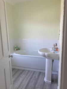 a bathroom with a white tub and a sink at Tennyson House in Hartlepool