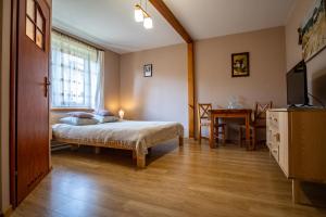um quarto com uma cama, uma janela e uma mesa em Siedlisko Leszczewek em Leszczewek