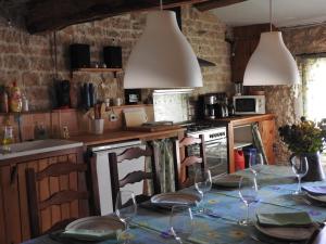 - une cuisine avec une table et des verres à vin dans l'établissement La maison de Léon, à Celles-sur-Belle