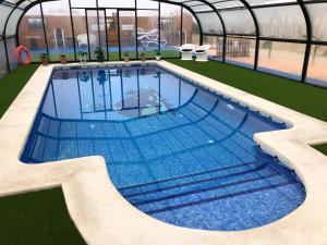 a large swimming pool in a green house with a swimming pool at La Escapada in Minaya