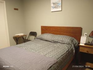 Schlafzimmer mit einem Bett mit einem Kopfteil aus Holz und einem Tisch in der Unterkunft Alojamientos JV HABITACIONES in Nogales