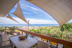 a table on a balcony with a view of the ocean at Villa- nefeli in Agios Gordios