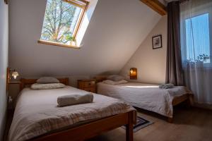 two beds in a room with a window at Siedlisko Leszczewek in Leszczewek