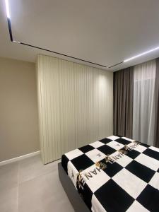 een slaapkamer met een zwart-wit geruit bed bij apartment in Tirana