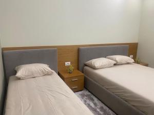 twee bedden naast elkaar in een kamer bij apartment in Tirana