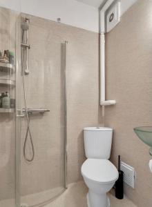 a bathroom with a toilet and a glass shower at Central Pearl Apartment in Reykjavík
