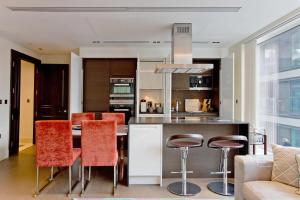 eine Küche und ein Wohnzimmer mit einem Tisch und Stühlen in der Unterkunft Luxurious West Kensington Flat with City Views in London