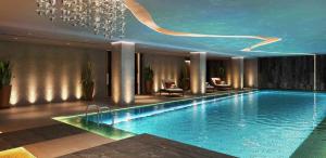 ein großer Pool in einem Hotel mit Kronleuchter in der Unterkunft Luxurious West Kensington Flat with City Views in London