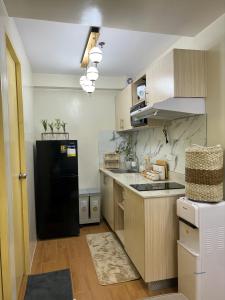 Babak的住宿－Scarlet Suites Condominium，厨房配有黑色冰箱和木制橱柜。