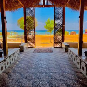 塔巴的住宿－Sayal Camp，享有海滩和大海景致的建筑
