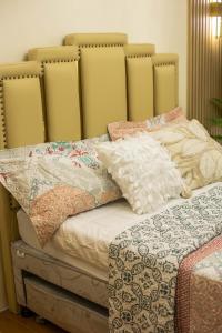 ein Bett mit vielen Kissen darüber in der Unterkunft Scarlet Suites Condominium in Babak
