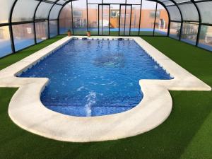 une grande piscine dans une maison verte dans l'établissement La Escapada, à Minaya