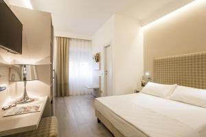 una camera d'albergo con letto e TV di Hotel Grottamare a Lido di Jesolo