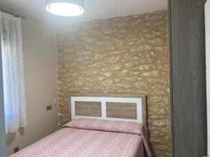 Dormitorio con cama y pared con aversión en La Escapada, en Minaya