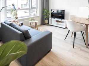 un soggiorno con divano e tavolo di 3-room's 1,5 Bath And Patio, Lovely Location a Eindhoven