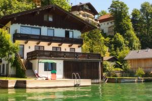 圣沃尔夫冈Seebad Appartements的湖畔水面上的房屋