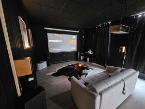 a living room with a couch and a projection screen at BLACK BOX CINEMA appartement avec balnéo in Épinal