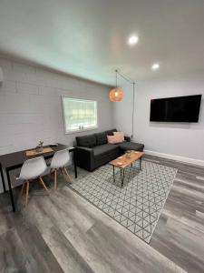 ein Wohnzimmer mit einem Sofa und einem Tisch in der Unterkunft NEW Designed Apt 2023 NrUCF PETSOk PrivateEntry in Orlando