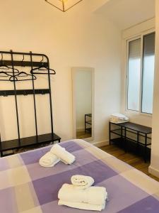 1 dormitorio con 1 cama con toallas en Patio de Los Barberos, en Valle de Abdalajís