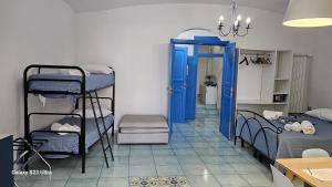ナポリにあるNapoli Lungomare Caracciolo Mon Amourの二段ベッドと青いドアが備わる客室です。