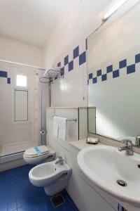 a white bathroom with a sink and a toilet at Hotel Grottamare in Lido di Jesolo