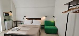 a small room with a bed and a green chair at Caure Vista Mare in Polignano a Mare