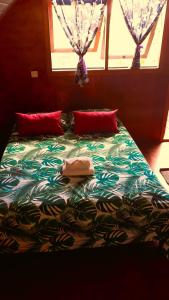 a large bed with two pillows and a window at Faré blue lagoon in Moorea