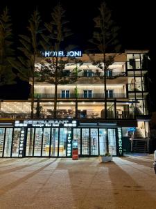 a hotel building with a sign on it at night at Hotel Joni in Ksamil