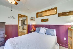 1 dormitorio con cama y pared púrpura en Historic Friendship Boat House Near Back River!, en Friendship