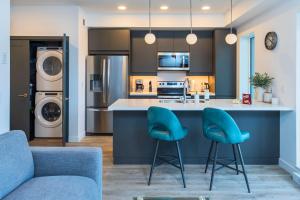 a kitchen with a counter and two blue chairs at NN - The Current 2 - Downtown 1-Bed 1-Bath in Whitehorse