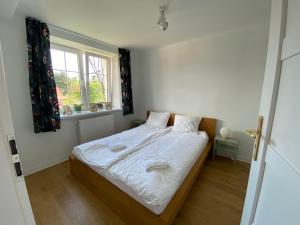 a bedroom with a bed with white sheets and a window at PrzyLądek Zdrój Bike Apart in Lądek-Zdrój