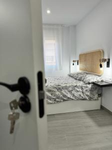 a bedroom with a bed and a desk and a window at Apartamento Maui beach en el palo in Málaga