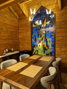a dining room with a table and a stained glass window at KRZ Cottages أكواخ الكرز in Ash Shafa