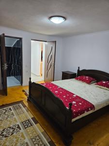 una camera da letto con un grande letto con cuscini rossi di Cabana Cezar a Budureasa