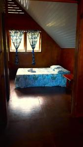 a bedroom with a bed in a attic with a window at Faré blue lagoon in Moorea