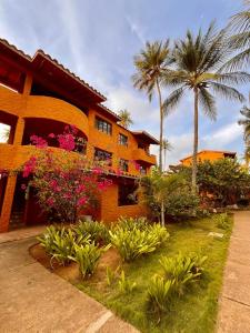 une maison avec des palmiers et des fleurs devant elle dans l'établissement Un Oasis entre Olas y Palmeras con Playa Privada, à Tucacas