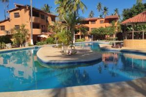 - une piscine avec un palmier au milieu dans l'établissement Un Oasis entre Olas y Palmeras con Playa Privada, à Tucacas