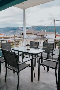 a table and chairs on a balcony with a view at Pamvotis Urban Suites in Ioannina