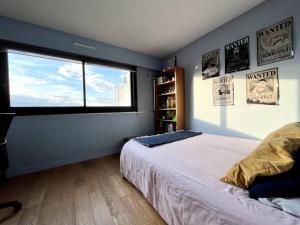 - une chambre avec un grand lit et une fenêtre dans l'établissement Jerickais Appartement à Rueil, à Rueil-Malmaison