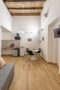 a living room with a table and a kitchen at Quattro Canti rooms in Palermo
