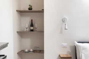 a bedroom with white walls and shelves with wine glasses at Quattro Canti rooms in Palermo