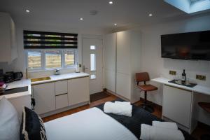 a living room with a bed and a kitchen at Heather Nook- luxury studio in Pitlochry in Pitlochry